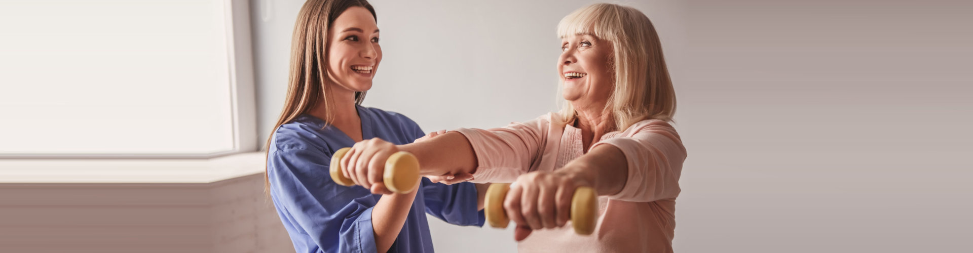 caregiver assisting elder woman in exercising